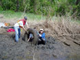 MDE's Renee Godinez and a volunteer remove a tire from the Anacostia River.