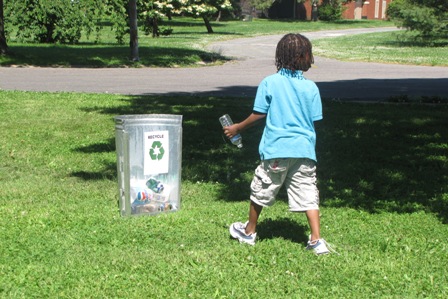 Child walking to recycle empty water bottle
