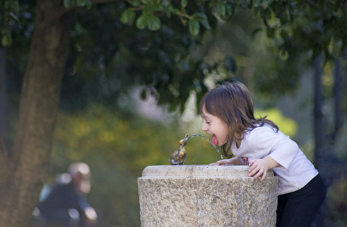 Little girl drinking from fountain