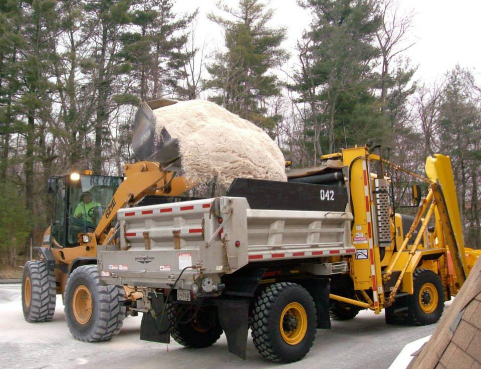 Tractor loading salt into a dump truck.