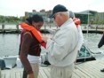 Secretary Kendl P. Philbrick helping a woman put on a life jacket
