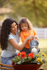 Photo of a mother and daughter watering a plant
