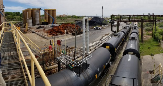 Complex industrial operation with a train yard and material storage.